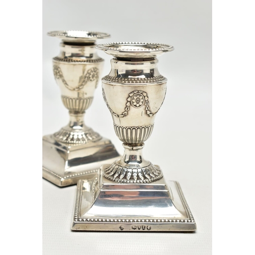 64 - A PAIR OF LATE VICTORIAN SILVER DWARF CANDLESTICKS, beaded rims throughout, the urn shaped candlehol... 