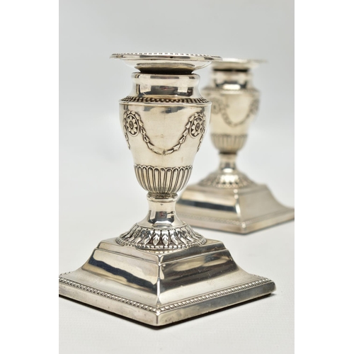 64 - A PAIR OF LATE VICTORIAN SILVER DWARF CANDLESTICKS, beaded rims throughout, the urn shaped candlehol... 