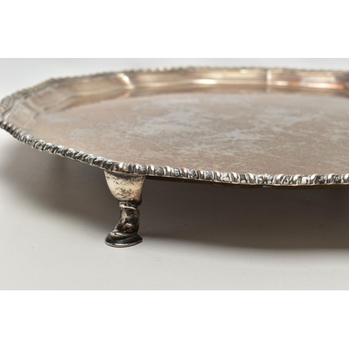 77 - A GEORGE V SILVER SALVER, with gadrooned Chippendale pie crust edge, plain centre, on four short cab... 