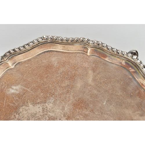 77 - A GEORGE V SILVER SALVER, with gadrooned Chippendale pie crust edge, plain centre, on four short cab... 