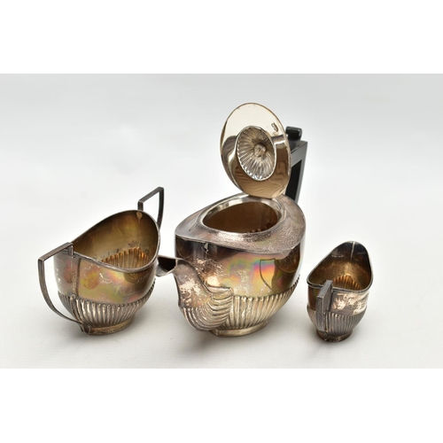 83 - A GEORGE V SILVER THREE PIECE BACHELOR'S TEA SET OF OVAL FORM, the tea pot with ebonised fitments, a... 