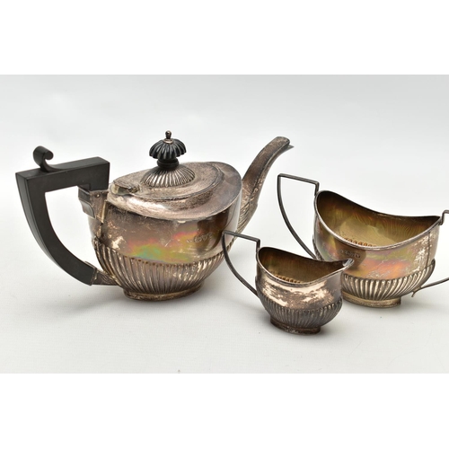 83 - A GEORGE V SILVER THREE PIECE BACHELOR'S TEA SET OF OVAL FORM, the tea pot with ebonised fitments, a... 