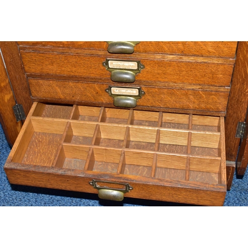 170 - OPTOMETRIST INTEREST: AN EARLY 20TH CENTURY RECTANGULAR OAK CABINET WITH GLAZED CASE ABOVE NINE DRAW... 