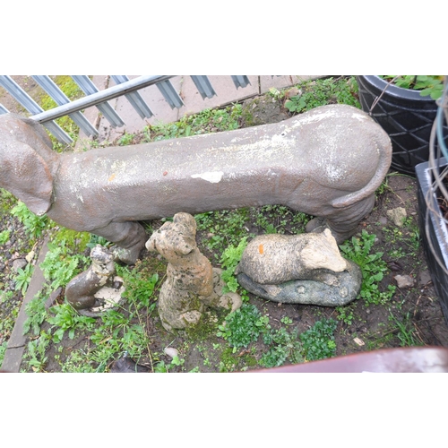 1018 - FOUR ANIMAL FIGURE GARDEN ORNAMENTS including a plastic Dachshund seat 115cm long, a composite Boxer... 