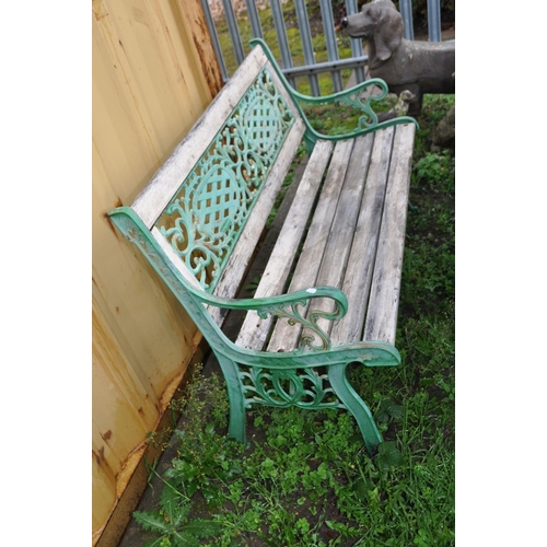 1021 - A WOODEN SLATTED GARDEN BENCH with cast iron ends and back panel 127cm wide (Condition weathered fin... 