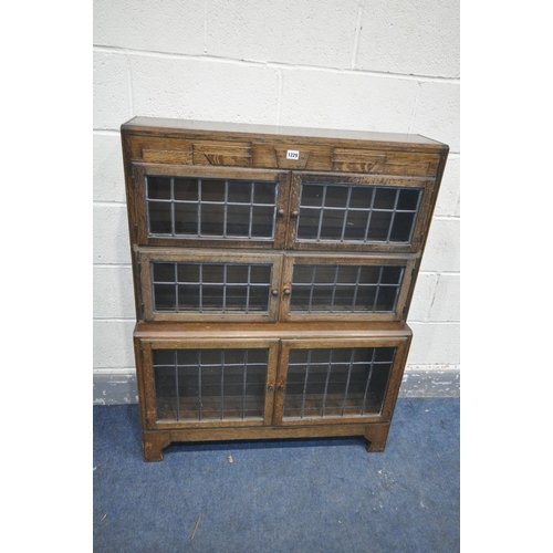 1229 - AN EARLY 20TH CENTURY OAK SECTIONAL BOOKCASE, made up of three tier that have double lead glazed doo... 