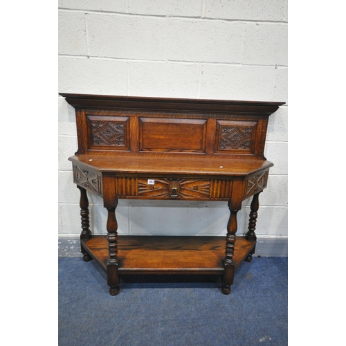 1263 - A 20TH CENTURY CANTED OAK SIDE TABLE, with a raised panelled back, a single frieze drawer, on turned... 