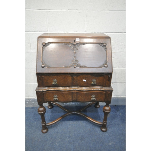 1269 - AN EARLY 20TH CENTURY OAK BUREAU, with two drawers, on bulbous legs, united by a cross stretcher, wi... 