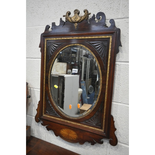 1316 - AN EARLY 19TH CENTURY MAHOGANY AND GILT FRETWORK FRAMED WALL MIRROR, with an oval bevelled plate, wi... 