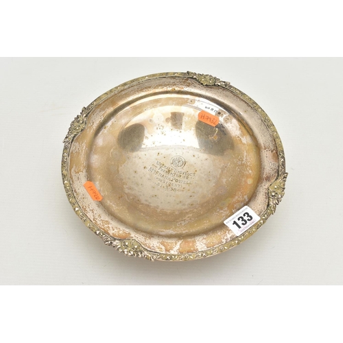 133 - A SILVER RAISED DISH, of a circular form, floral detailed rim, personal engraving to the centre read... 