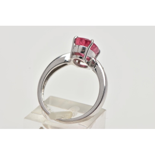 17 - AN 18CT WHITE GOLD RING, centrally set with an oval cut orange/red colour corundum, flanked with two... 