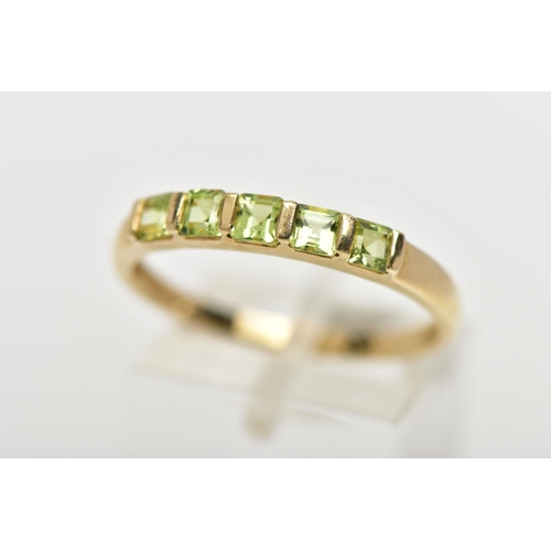 47 - A 9CT GOLD PERIDOT RING, designed with a row of five bar set, square cut peridots, to a polished ban... 