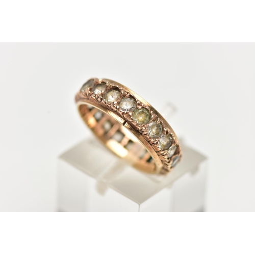 5 - A YELLOW METAL FULL ETERNITY RING, set with a row of circular cut colourless stones assessed as spin... 