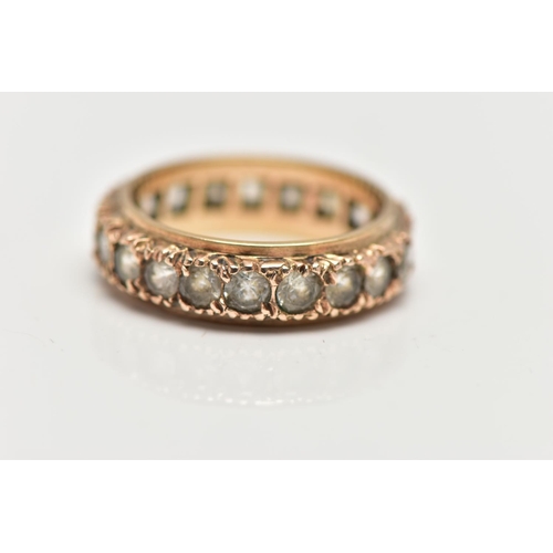 5 - A YELLOW METAL FULL ETERNITY RING, set with a row of circular cut colourless stones assessed as spin... 