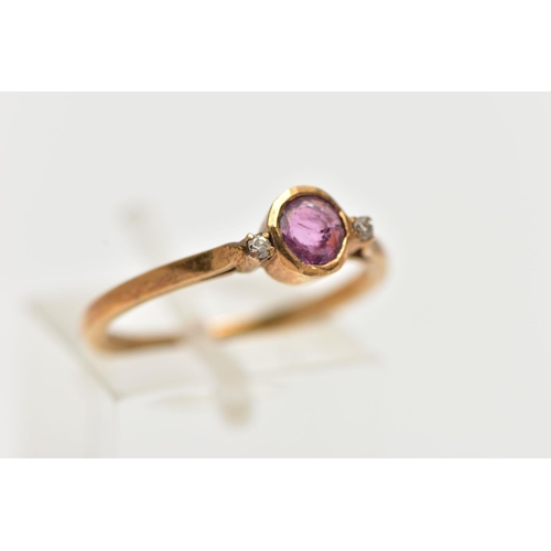 50 - A YELLOW METAL RUBY AND DIAMOND RING, designed with a collet set ruby, flanked with two small round ... 