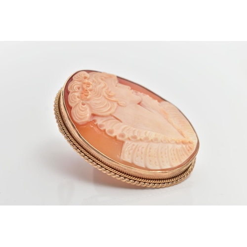 64 - A 9CT GOLD CAMEO BROOCH, of an oval form, carved shell depicting a lady in profile, collet set to a ... 