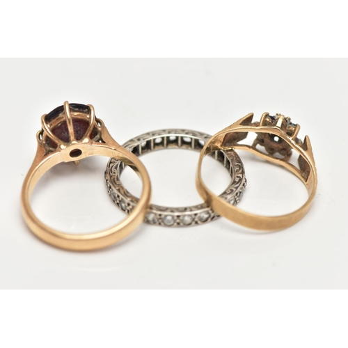 67 - THREE GEM SET RINGS, the first designed with an oval cut garnet in an eight claw setting with openwo... 