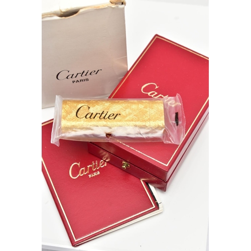 94 - AN UNUSED GOLD PLATED 'CARTIER' LIGHTER, unopened gold plated textured lighter, signed to the base '... 