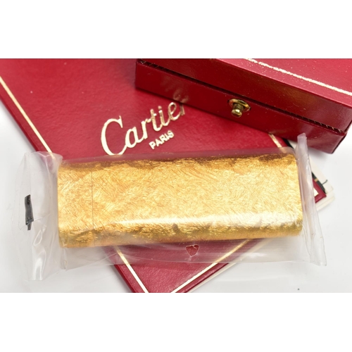 94 - AN UNUSED GOLD PLATED 'CARTIER' LIGHTER, unopened gold plated textured lighter, signed to the base '... 