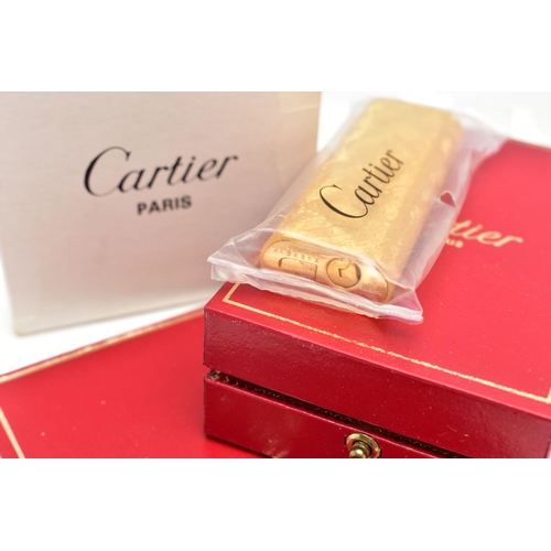 94 - AN UNUSED GOLD PLATED 'CARTIER' LIGHTER, unopened gold plated textured lighter, signed to the base '... 