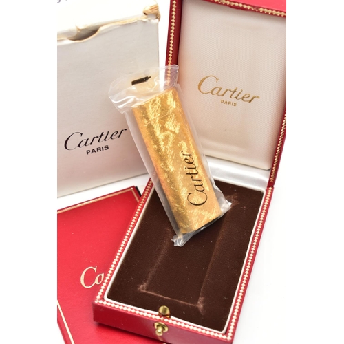 94 - AN UNUSED GOLD PLATED 'CARTIER' LIGHTER, unopened gold plated textured lighter, signed to the base '... 