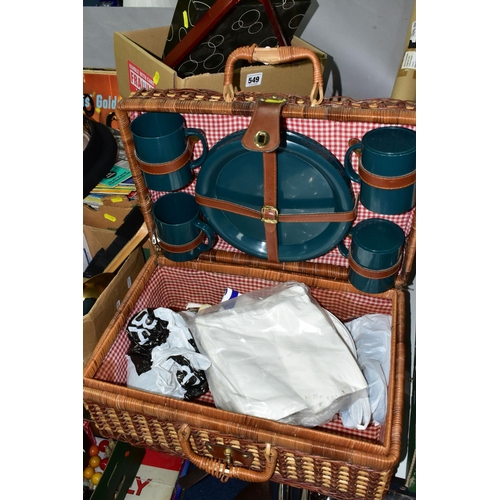 549 - FOUR BOXES OF SUNDRIES AND ONE PICNIC BASKET, to include a black Breton cap, a large brass vintage c... 