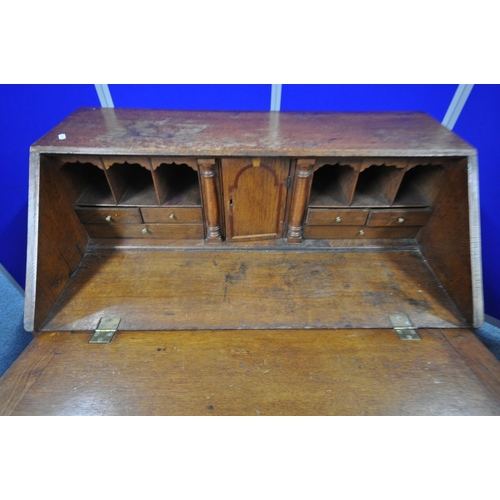 1203 - A GEORGIAN OAK FALL FRONT BUREAU, with a fitted interior, with four long graduated drawers, on brack... 