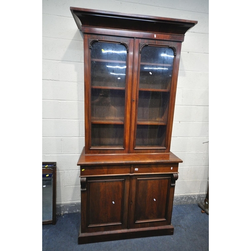 1205 - A VICTORIAN MAHOGANY BOOKCASE, with an overhanging cornice, two glazed doors, enclosing three adjust... 