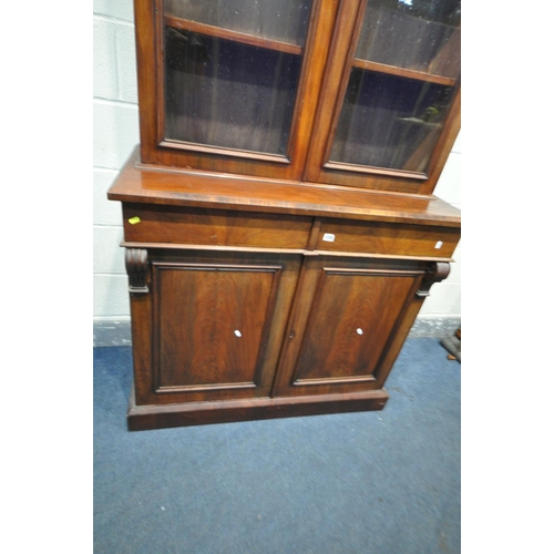 1205 - A VICTORIAN MAHOGANY BOOKCASE, with an overhanging cornice, two glazed doors, enclosing three adjust... 