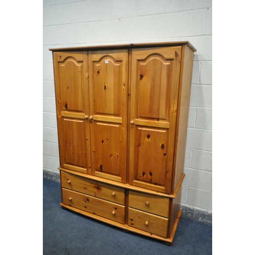 1210 - A MODERN PINE TRIPLE DOOR WARDROBE, with four drawers, width 138cm x depth 54cm x height 184cm (cond... 