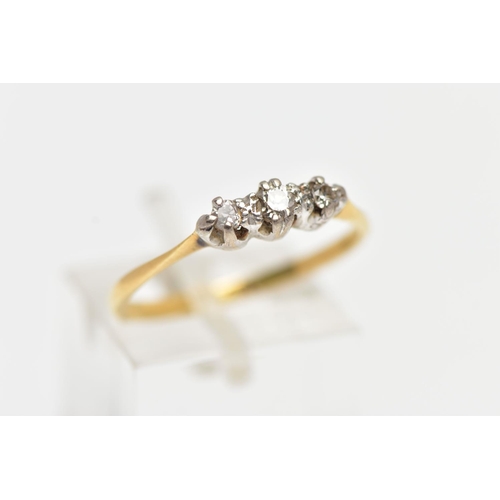 25 - A YELLOW METAL THREE STONE DIAMOND RING, centering on a claw set, round brilliant cut diamond, flank... 