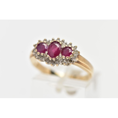 26 - A 9CT YELLOW GOLD RUBY AND DIAMOND CLUSTER RING, designed with three graduated oval cut rubies to th... 