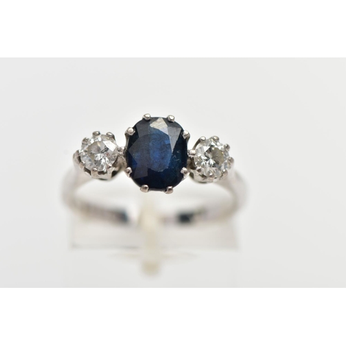 4 - AN 18CT WHITE GOLD SAPPHIRE AND DIAMOND THREE STONE RING, centering on an oval cut deep blue sapphir... 