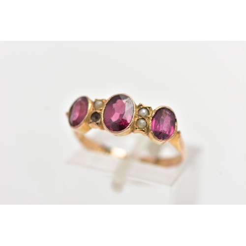 47 - AN EARLY 20TH CENTURY 9CT GOLD GEM SET RING, designed with three oval cut graduated garnets, intersp... 