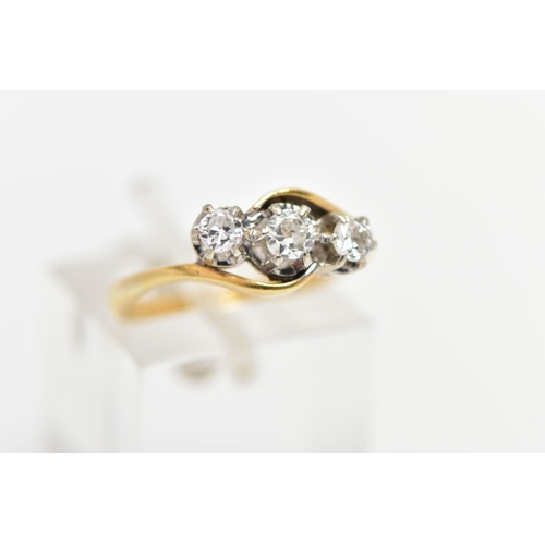 61 - A YELLOW METAL THREE STONE DIAMOND RING, three claw set, round brilliant cut diamonds, within cross ... 