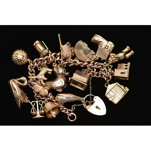 7 - A 9CT YELLOW GOLD CHARM BRACELET, the curb link chain, with padlock clasp, suspending approximately ... 