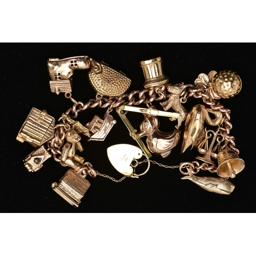 7 - A 9CT YELLOW GOLD CHARM BRACELET, the curb link chain, with padlock clasp, suspending approximately ... 
