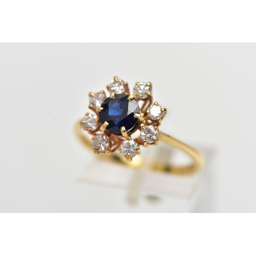 72 - AN 18CT YELLOW GOLD SAPPHIRE AND DIAMOND CLUSTER RING, centering on a circular cut blue sapphire, in... 