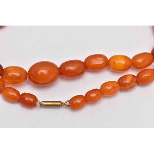 78 - A GRADUATED AMBER BEAD NECKLACE, largest oval bead measuring approximately 14.5mm, smallest measurin... 