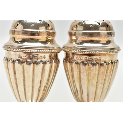 79 - A PAIR OF VICTORIAN SILVER PEPPERETTES, each of a tapering form, stop reeded design, on weighted squ... 