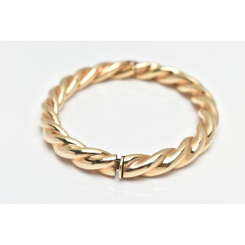 8 - A MODERN 9CT YELLOW GOLD HINGED BANGLE, designed as a plain polished twist, with concealed push piec... 