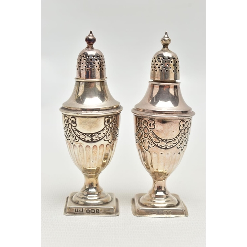 80 - A PAIR OF SILVER PEPPERETTES, each of an urn form, decorated with a bow and swag design with stop re... 