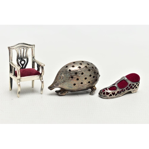 83 - THREE WHITE METAL PIN CUSHIONS, to include a textured hedgehog, with pin holes, unmarked, a small ch... 
