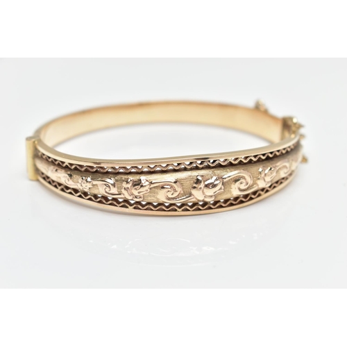 9 - A MID 20TH CENTURY SMITH AND PEPPER 9CT YELLOW GOLD HINGED BANGLE, the front designed as an embossed... 