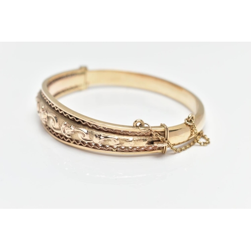 9 - A MID 20TH CENTURY SMITH AND PEPPER 9CT YELLOW GOLD HINGED BANGLE, the front designed as an embossed... 