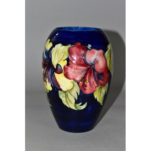 342 - A MOORCROFT POTTERY VASE, of baluster form with a mauve and yellow Hibiscus pattern on a blue ground... 