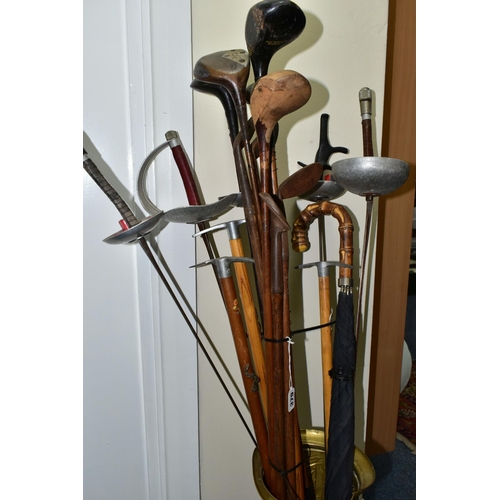 379 - A STICK STAND CONTAINING FENCING FOILS, VINTAGE GOLF CLUBS AND ICE PICKS, the brass stick stand heig... 