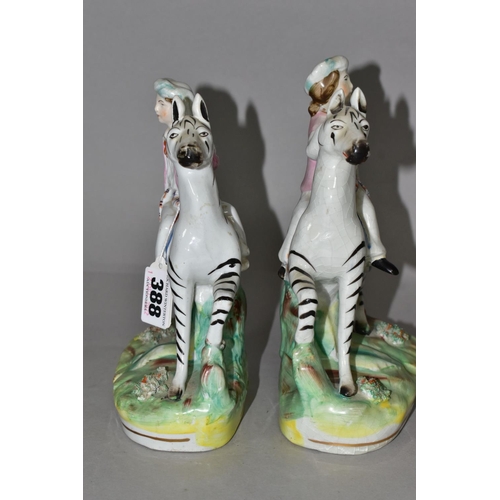 388 - A PAIR OF STAFFORDSHIRE ZEBRAS, each being ridden in a naturalistic landscape, height approximately ... 