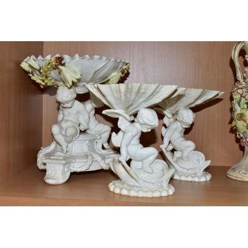 389 - SEVEN CERAMIC PIECES WITH MOULDED CHERUB DECORATION, comprising a centrepiece encrusted with flowers... 