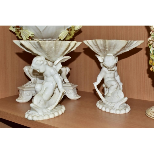 389 - SEVEN CERAMIC PIECES WITH MOULDED CHERUB DECORATION, comprising a centrepiece encrusted with flowers... 